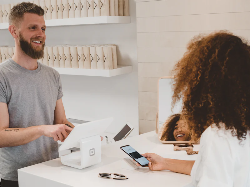 A customer paying by phone at a shop counter